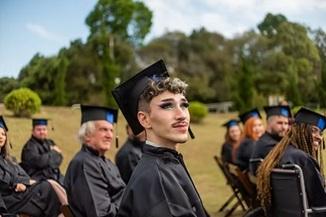 סטודנטים מסיימים לימודים עם חליפות מיוחדות וכבעים