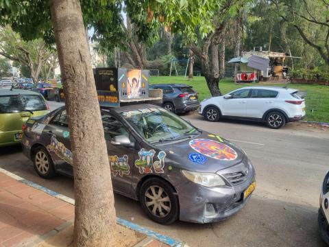 רכב ברסלב החונה ליד גינת הילדים וסמוך לעגלת הקפה הפתוחה בשבת
