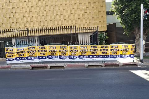 שלטים "צעדת האלפים לעזה" על מעקה של המדרכה
